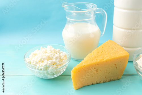 Dairy products. Cottage cheese, cheese, milk and kefir on blue wooden background with copy space.