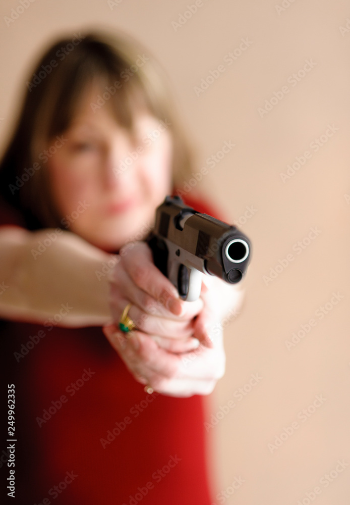 Blurred woman in red dress holding a gun Blurred woman in red dress holding a gun