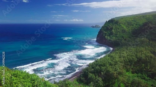 Flight over the green tropical coast of the Pacific ocean with waves and steep cliffs. Big Island, Hawaii