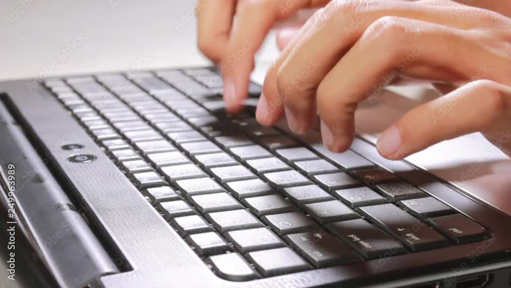 man's hands printing text on laptop keyboard - change in focus