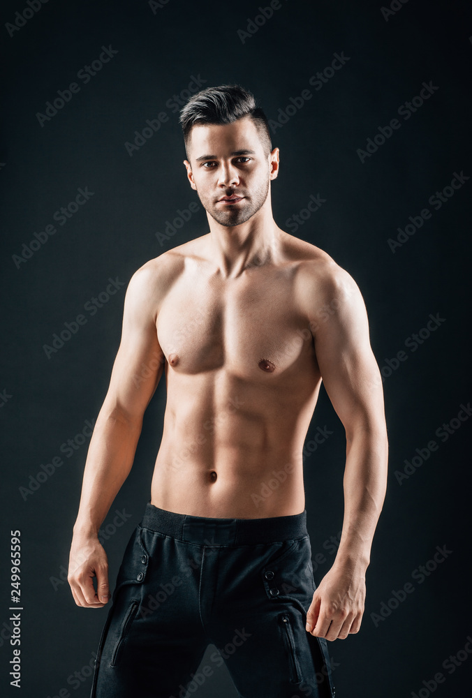 Sexy muscular shirtless man posing on black background Sexy muscular shirtless man posing on black background