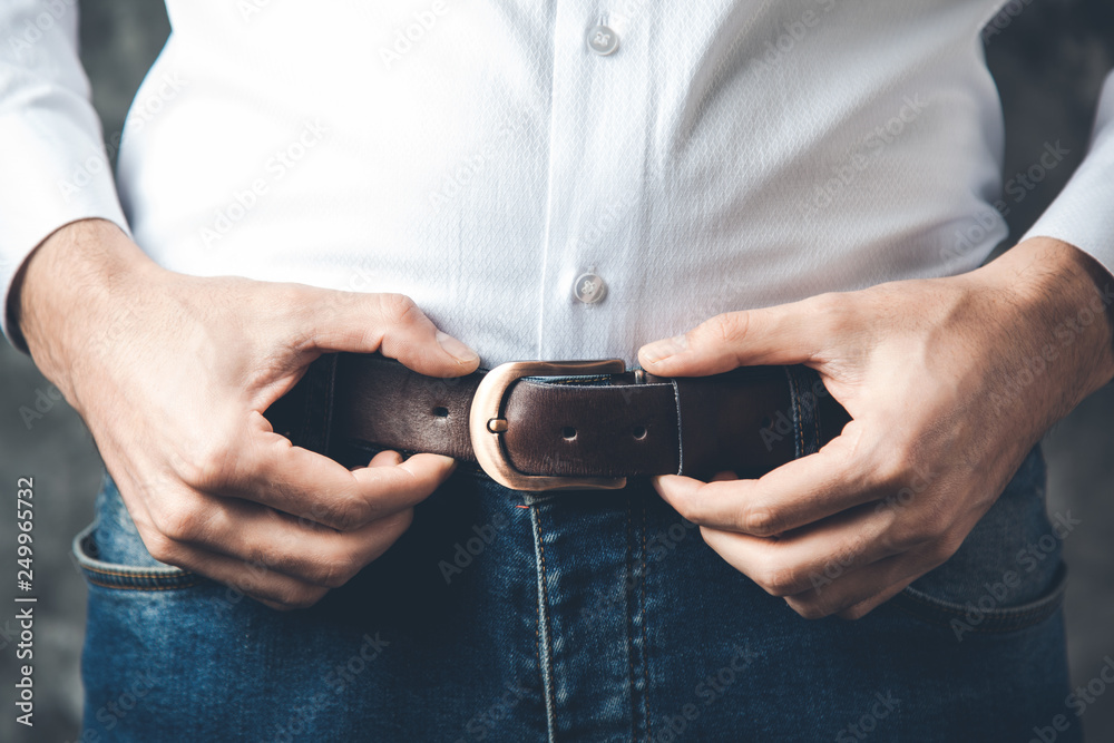 man hand on belt on dark background man hand on belt on dark background