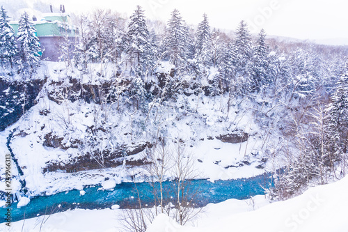 Beautiful outdoor nature landscape with shirahige waterfall and bridge in snow winter season photo