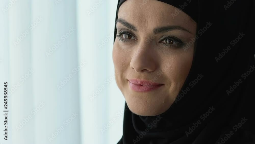 Cheerful pretty arab female in hijab smiling, female wellness and happiness