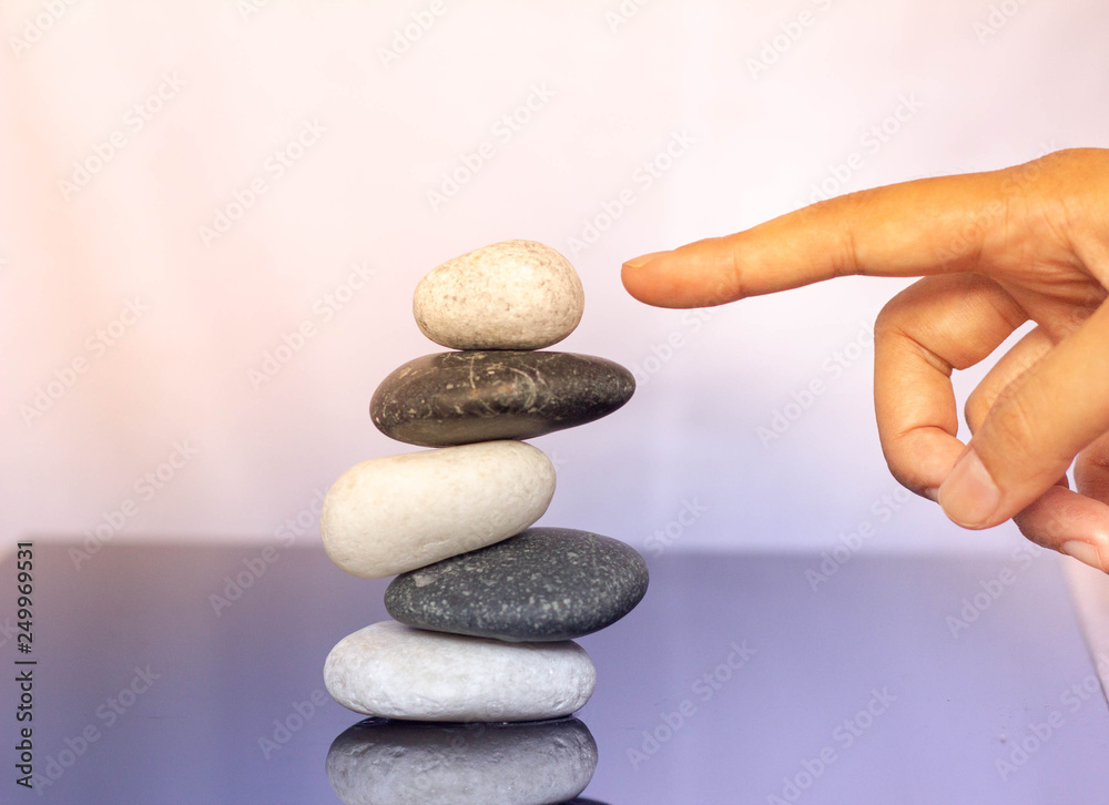 Women finger pointing and organizing stacks of zen stones. Women finger pointing and organizing stacks of zen stones.