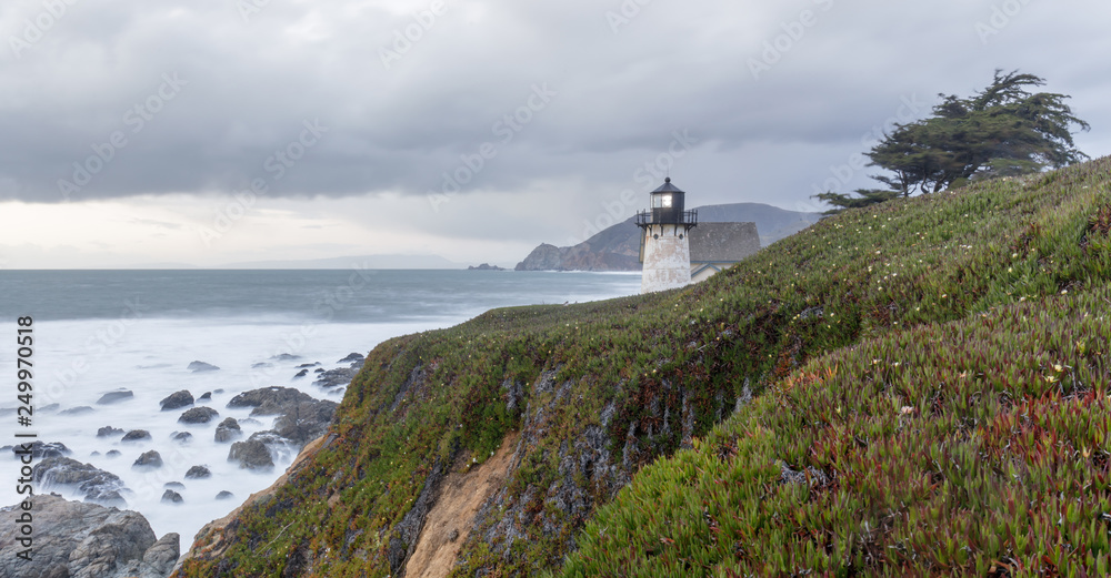 Point Montara Lighthouse and the Pacific Ocean Coastline on a winter evening. Montara, San Mateo County, California, USA.