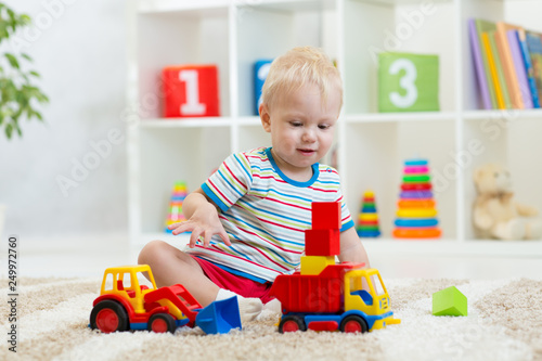 Nursery kid playing toy car...