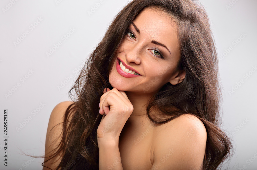 Beautiful natural makeup toothy smiling woman with long hair style. Skincare concept. Closeup portrait on blue background Beautiful natural makeup toothy smiling woman with long hair style. Skincare concept. Closeup portrait on blue background