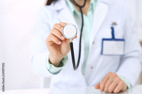 Unknown doctor holds stethoscope head, close-up. Medical help and insurance in health care, best treatment and medicine concept