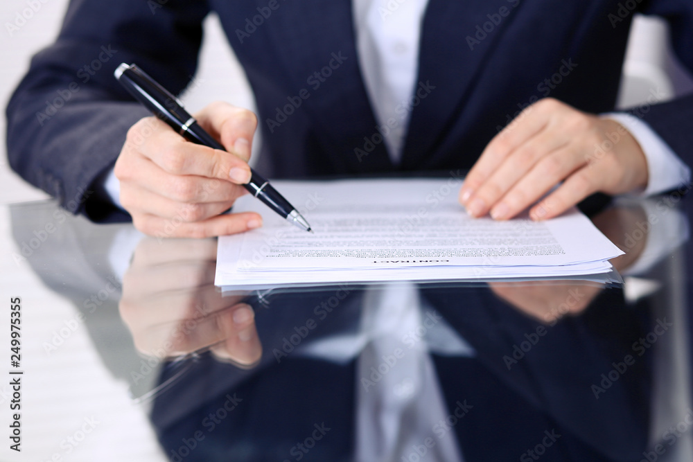 Unknown female hands with pen over document of contract. Agreement signing or business concept Unknown female hands with pen over document of contract. Agreement signing or business concept