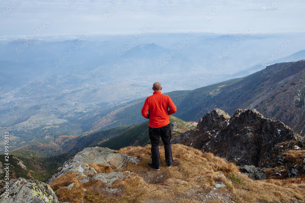 The young man of sporting physique rises to the mountain with sporting equipment The young man of sporting physique rises to the mountain with sporting equipment