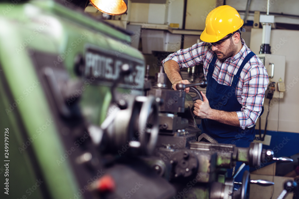 Turner worker is working on a lathe machine in a factory Turner worker is working on a lathe machine in a factory