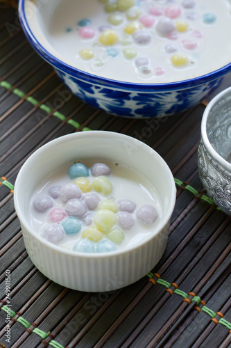 Color of Rice Dumpling in Coconut Milk (Bua Loy) in white bowl on wooden table for served in party. Famous dessert in Thailand. Sweet and delicious food.