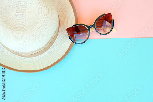 Fashionable hat and sunglasses on a multi-colored background.