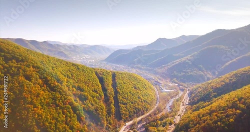 Great aerial view of small city Dalnegorsk (far in the mountains) in Russian Far East and small flowing stream. It's situated in the heart of Sikhote-Alin mountains range covered with forests photo