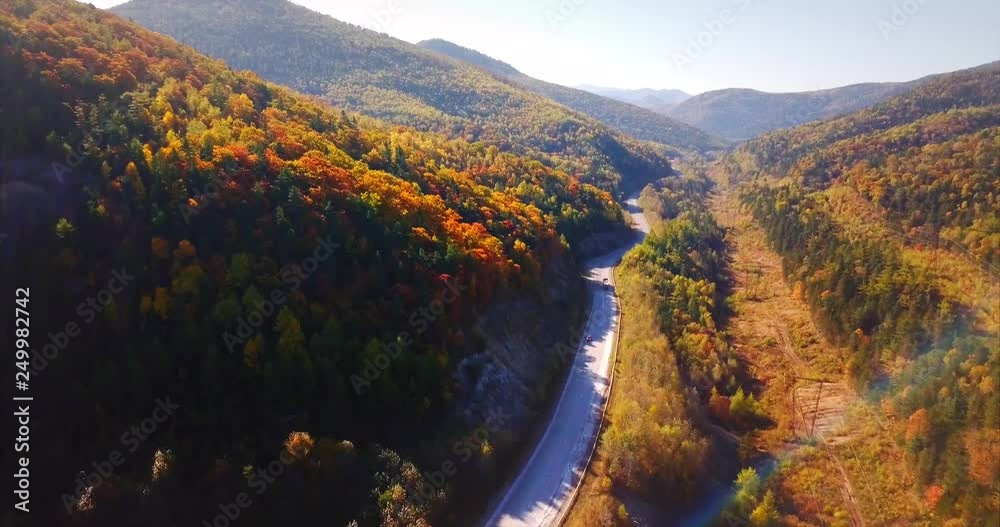 Aerial view of Dalnegorsky mountain pass and cars driving along the road. Beautiful Sikhote-Alin mountain range covered with endless autumn forests. Russia Aerial view of Dalnegorsky mountain pass and cars driving along the road. Beautiful Sikhote-Alin mountain range covered with endless autumn forests. Russia