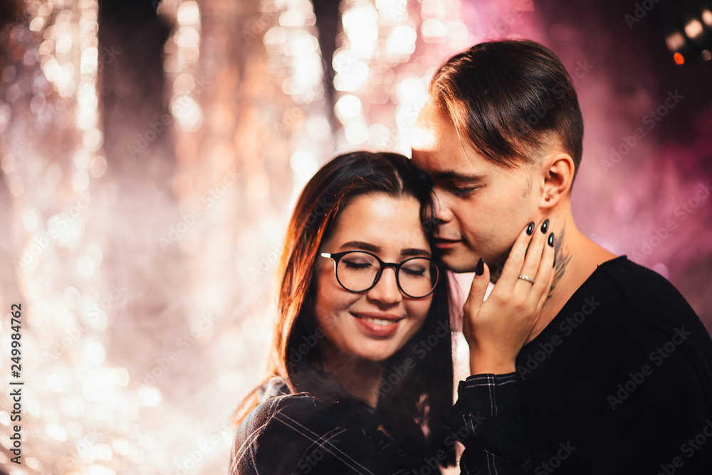 Couple in fashionable clothes on a shiny background