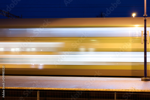 Train in motion on the station at night, long exposure photo.