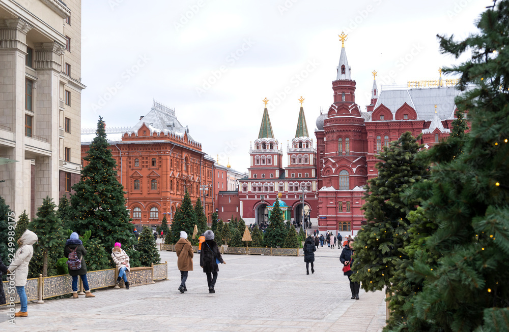 Moscow, the entrance to the red square in the winter spruce trees, people walk down the street