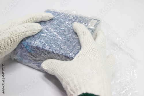 Man are using a bubble wrap wrapped Packing and protection brown box to prevent impact damage during transport.