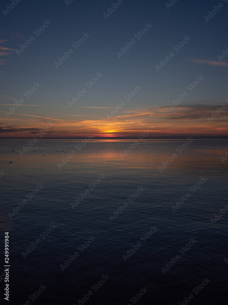 Sunset on the water. Vertical landscape.