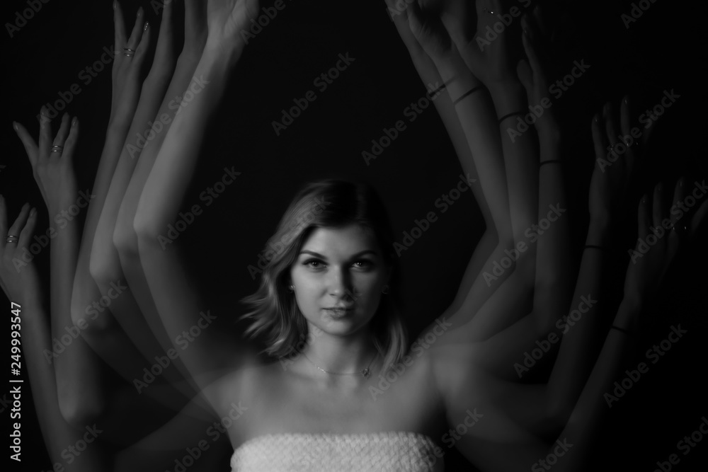Stroboscopic photo of young woman with moving hands on dark background Stroboscopic photo of young woman with moving hands on dark background