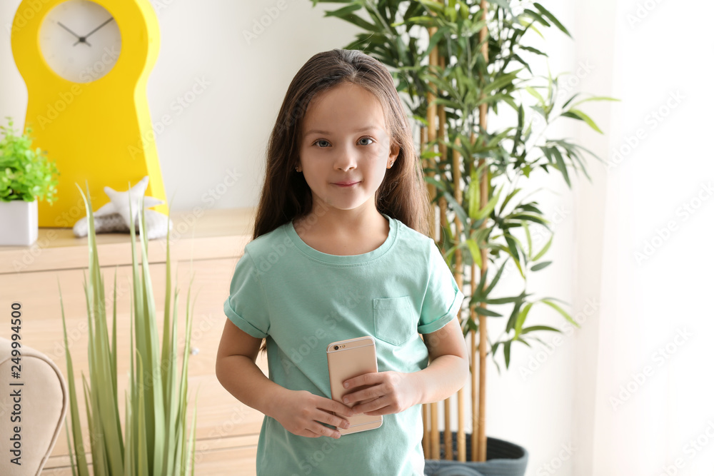 Portrait of cute little girl with mobile phone at home Portrait of cute little girl with mobile phone at home