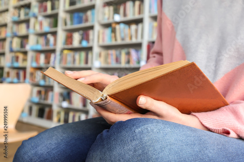 Young woman reading book in...