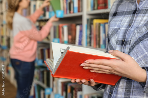 Young woman choosing book i...