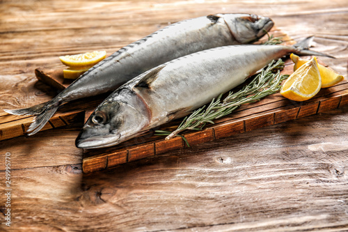 Board with tasty raw mackerel fish on wooden table