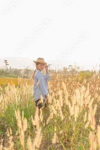 Girl wearing a hat Sitting looking at desho grass.