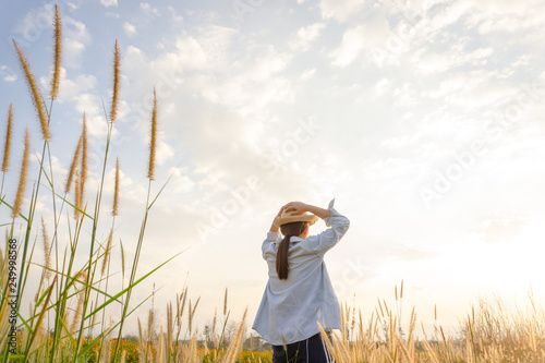 Girl wearing a hat Sitting looking at desho grass.