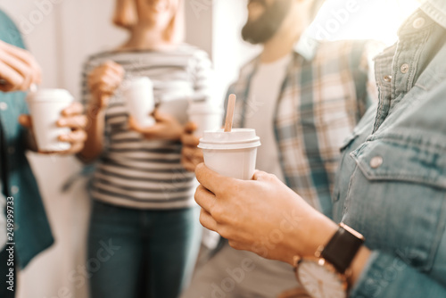 Quadro su tela Close up of hands holding coffee to go
