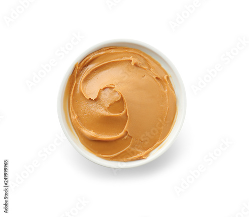 Tasty peanut butter in bowl on white background