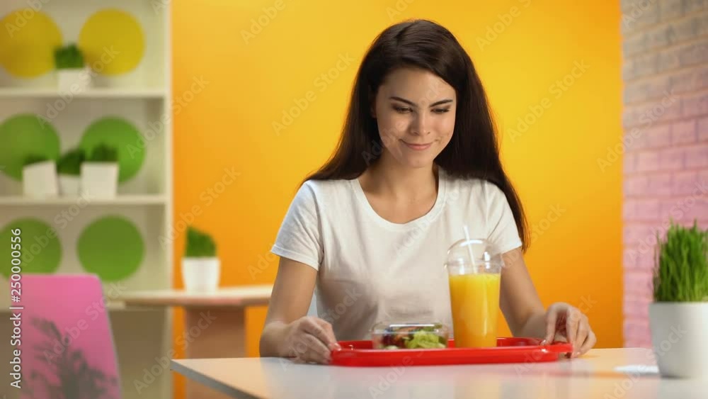 Happy woman putting tray with salad and fresh orange juice on table, snack bar Happy woman putting tray with salad and fresh orange juice on table, snack bar