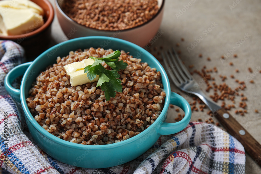 Pot with tasty boiled buckwheat on grey table Pot with tasty boiled buckwheat on grey table