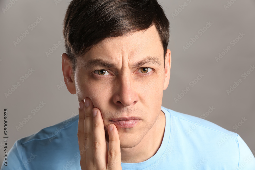 Frowning shaved man on grey background Frowning shaved man on grey background