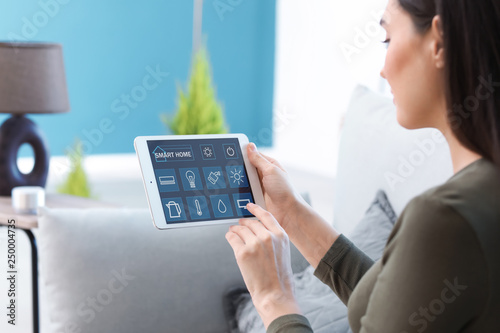 Young woman using application of smart home automation photo