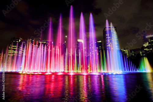 The colorful of fountain on the lake at night, near by Twin Towers; with city on background. Kuala Lumpur, Malaysia.