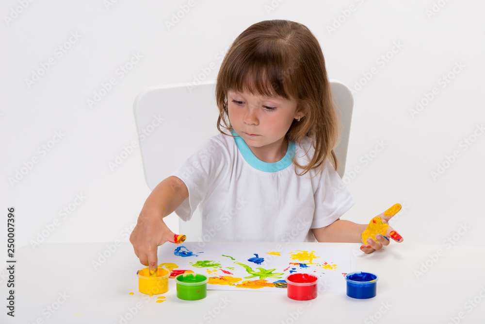Close-up portrait of a cute cheerful happy smiling little girl draws her own hands with gouache or finger paints isolated on white background Close-up portrait of a cute cheerful happy smiling little girl draws her own hands with gouache or finger paints isolated on white background