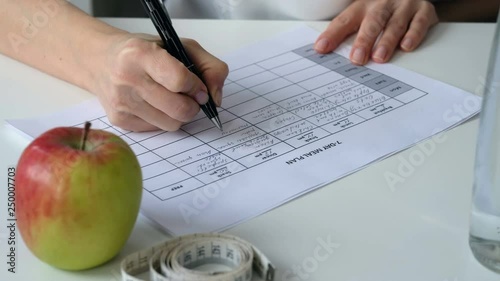 Nutritionist doctor writing diet plan on table. Healthy lifestyle and healthy food concept. Close up