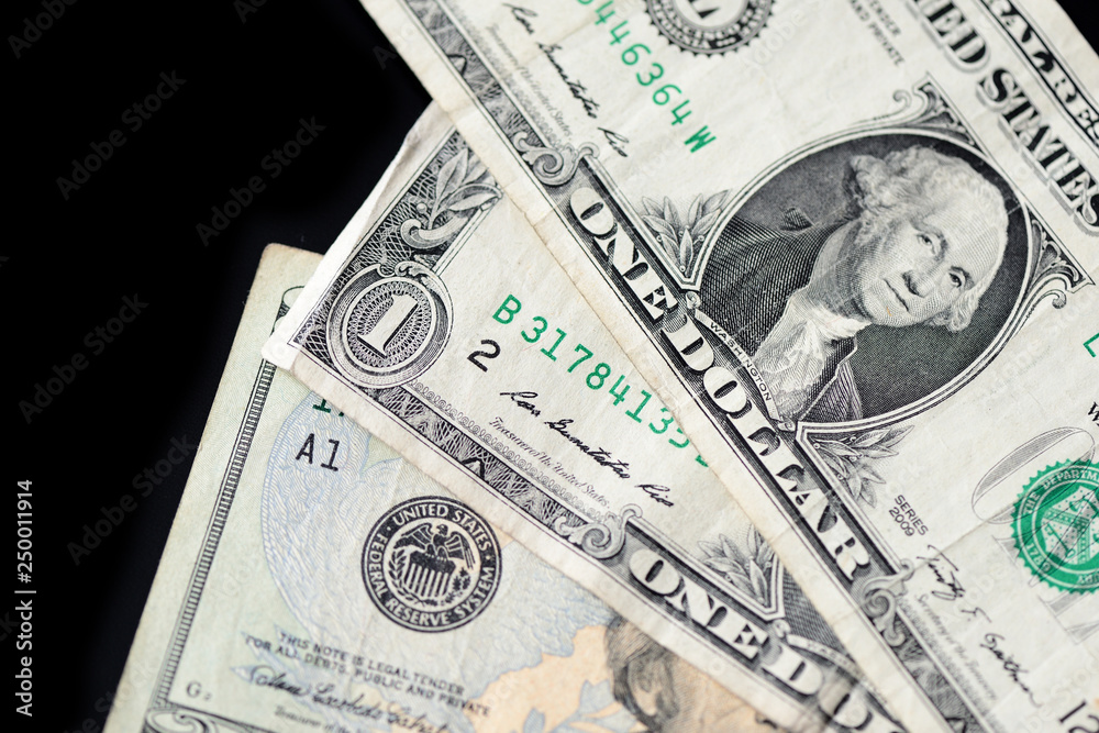 A few dollar bills on dark background close up A few dollar bills on dark background close up