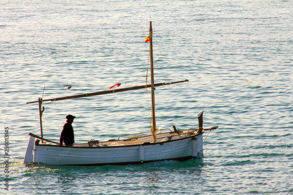 A small fishing boat entering the port in Denia, Spain