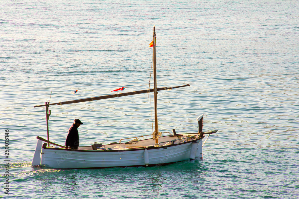 A small fishing boat entering the port in Denia, Spain