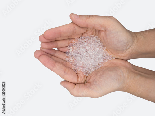 Close up of hand holding silica gel on white background, Desiccant attract moisture for chemical.