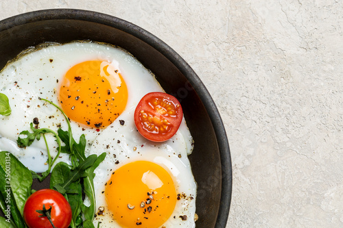 Photos Border with fried eggs with herbs and cherry tomatoes on pan