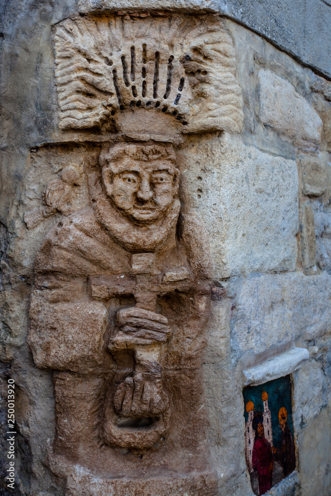 Bassorilievo sul muro presso Castello di Vigoleno, in Emilia Romagna provincia di Piacenza,  con le mura e la cittadina