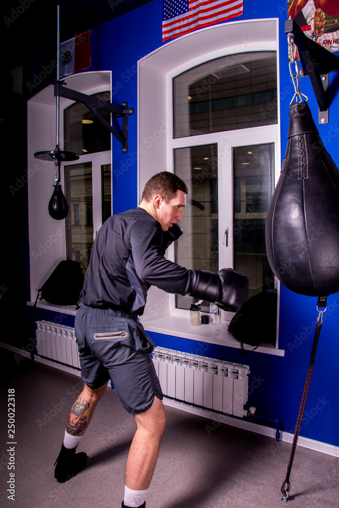 Boxer white young man during training in the gym