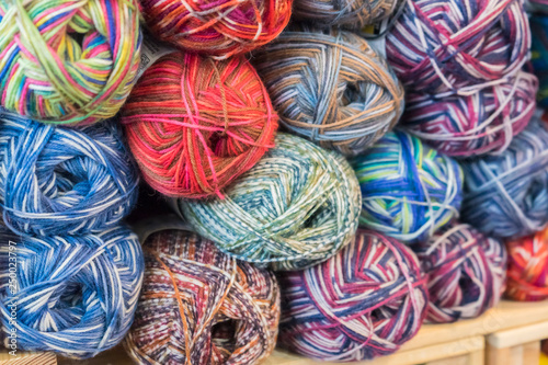 Knitting needles, colorful threads. Knitting pattern of colorful yarn wool on shopfront. Knitting background. Knitting yarn for handmade winter clothes. Colorful background with yarn ball.