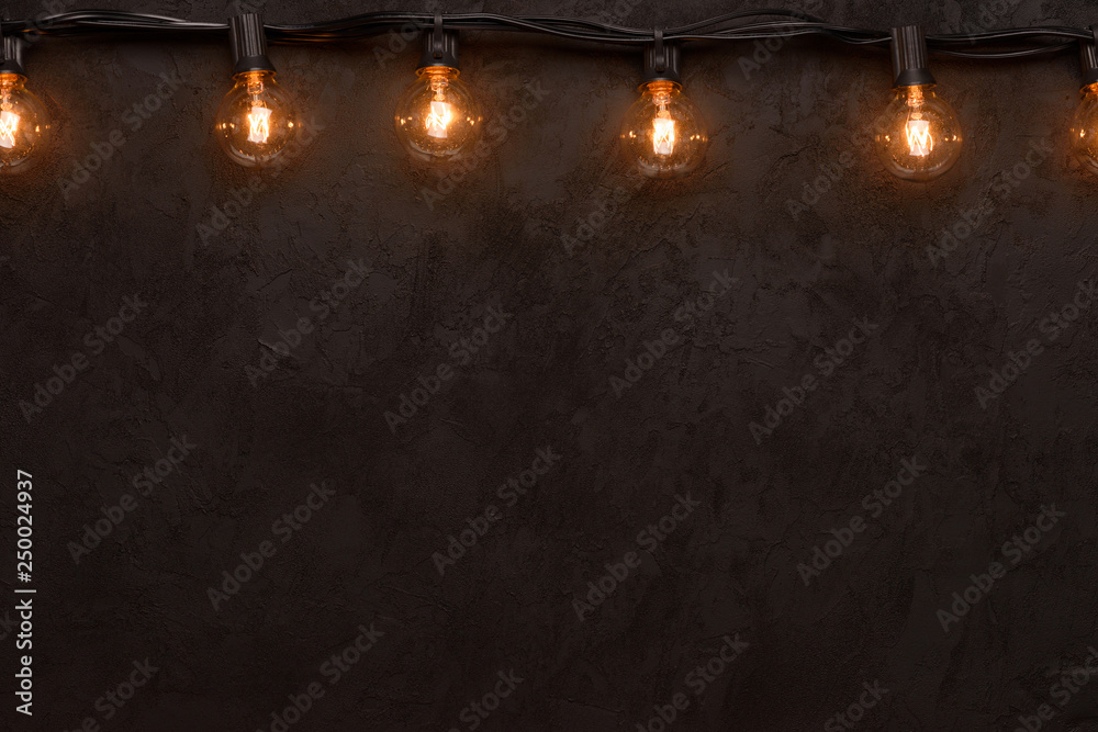 Light bulb string light on dark background top border with copy-space Light bulb string light on dark background top border with copy-space